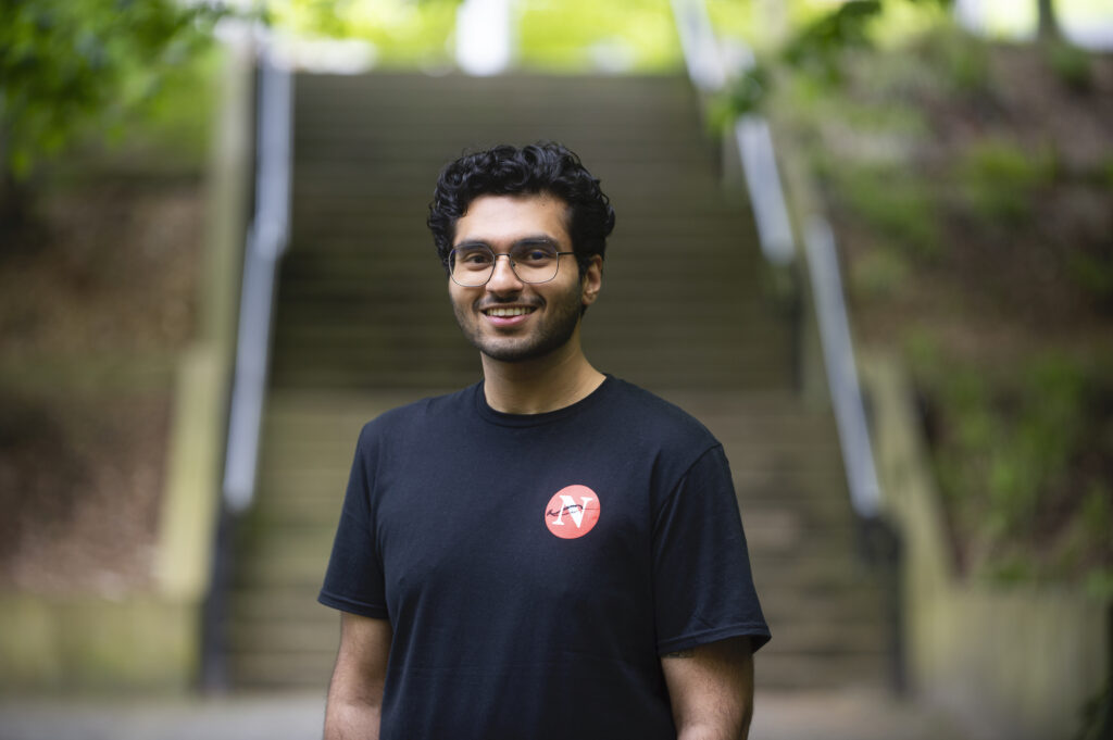 The Narwhal's audience fellow Karan Saxena stands in front of a set of stairs.