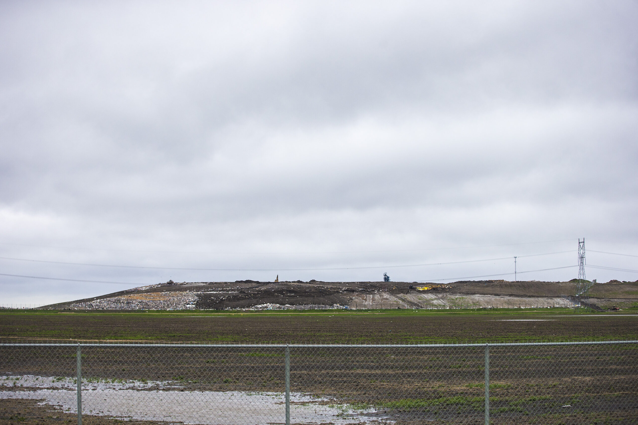 The Prairie Green Landfill looms above a foreground chain link fence