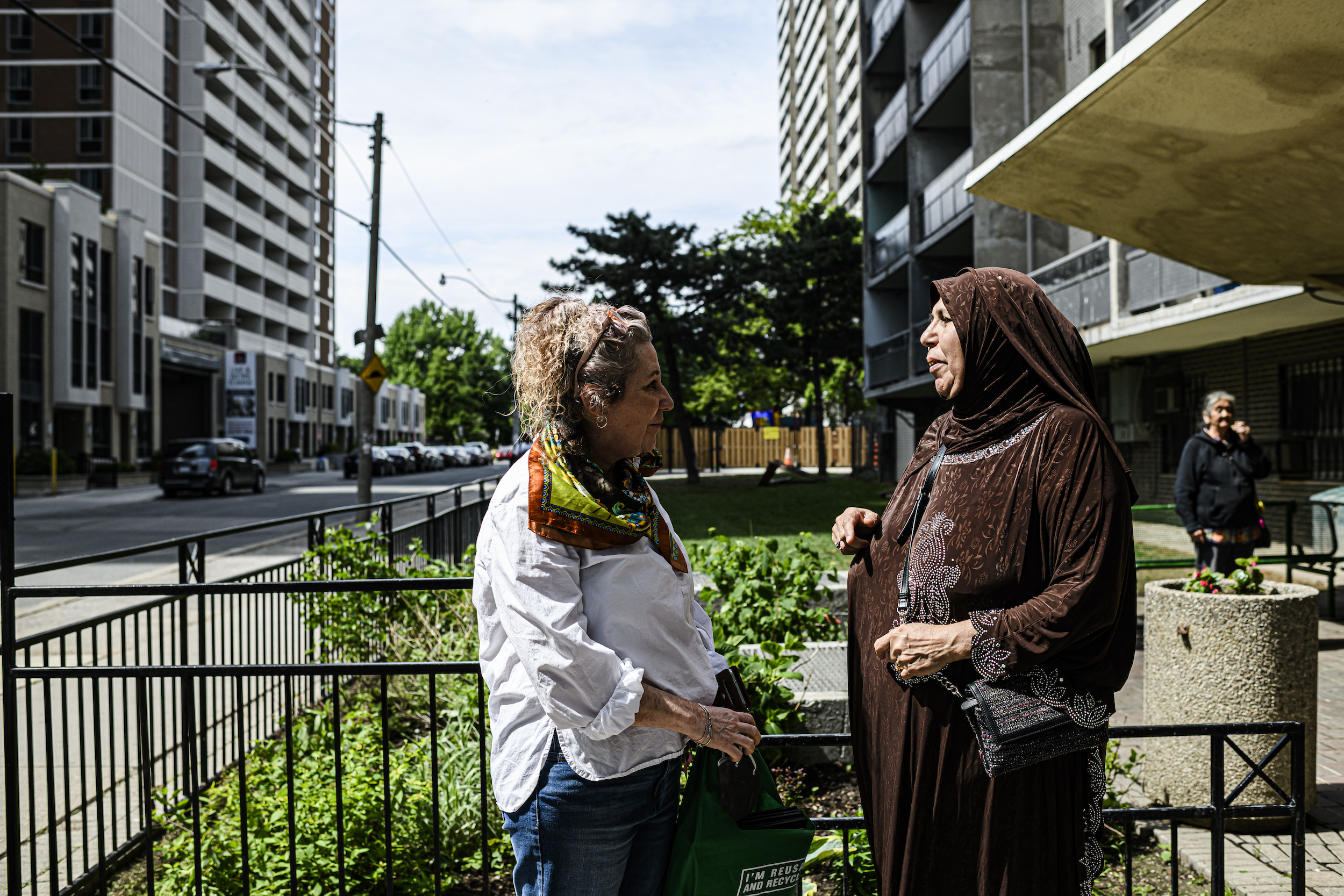 Lidia Ferriera (left), community animator with Community Resilience to Extreme Weather (CREW), meets with residents in St. James Town, Toronto.