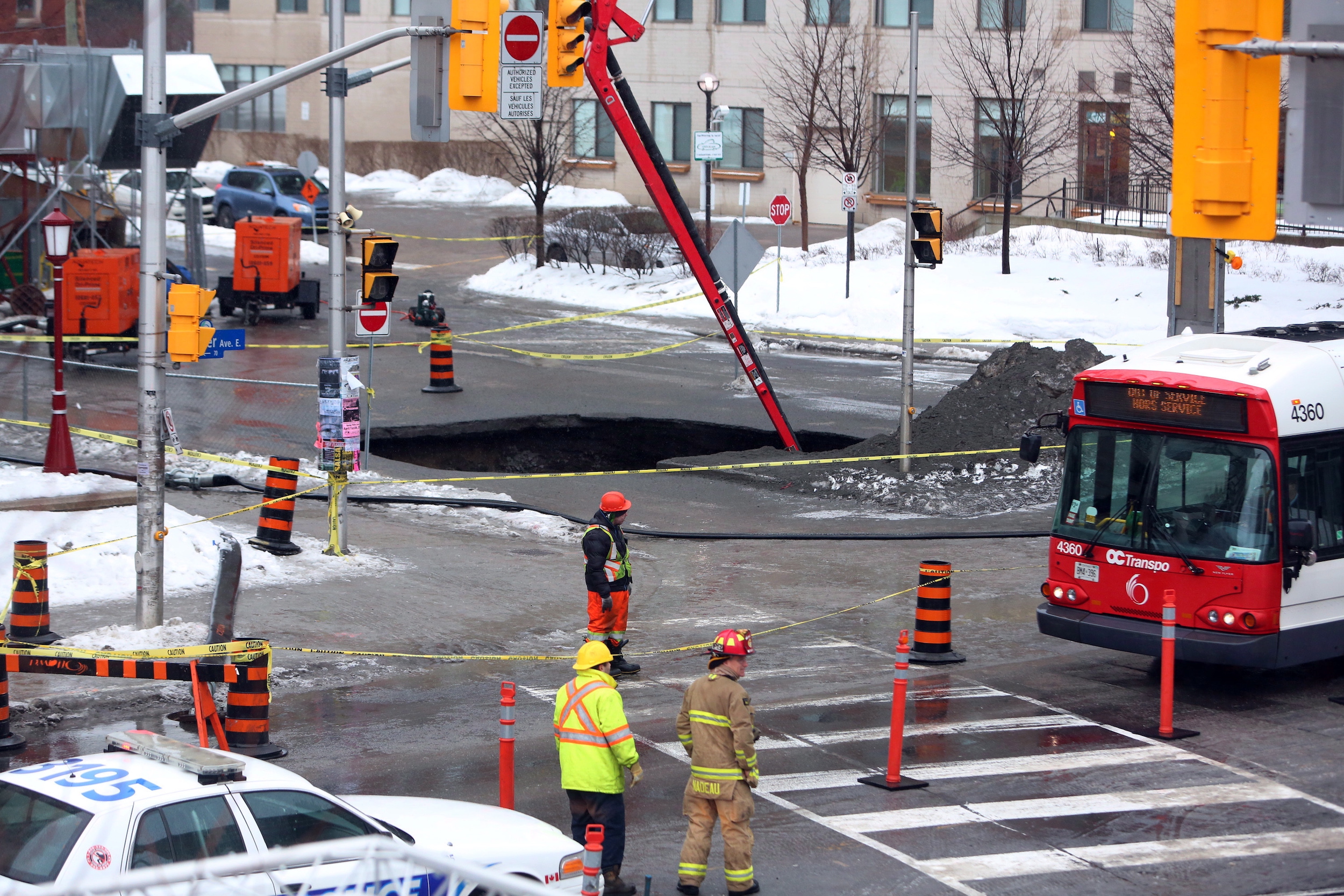 Crews work on a large sinkhole that halted tunneling work on the East Portal of Ottawa's LRT project. The cause of the sinkhole that police say is about eight metres wide has not been determined, Friday, February 21, in Ottawa, 2014.