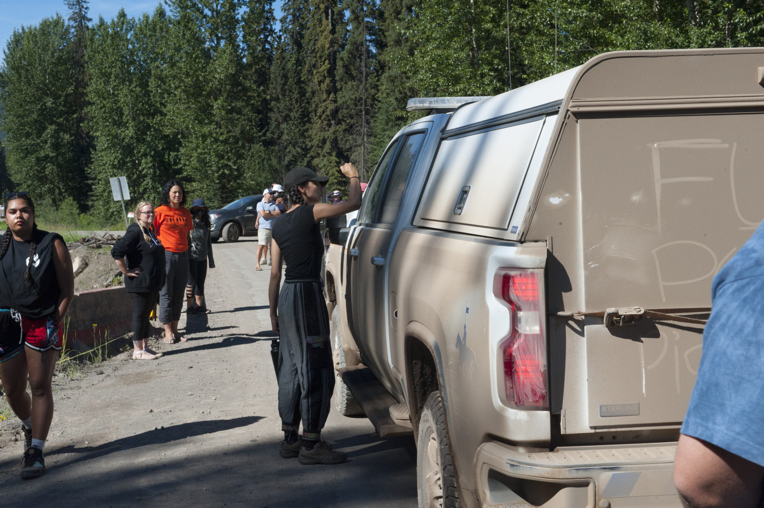Attendees of the Wet'suwet'en Peace and Unity Summit observe interactions between land defenders and the RCMP's Community-Industry Response Group (C-IRG)