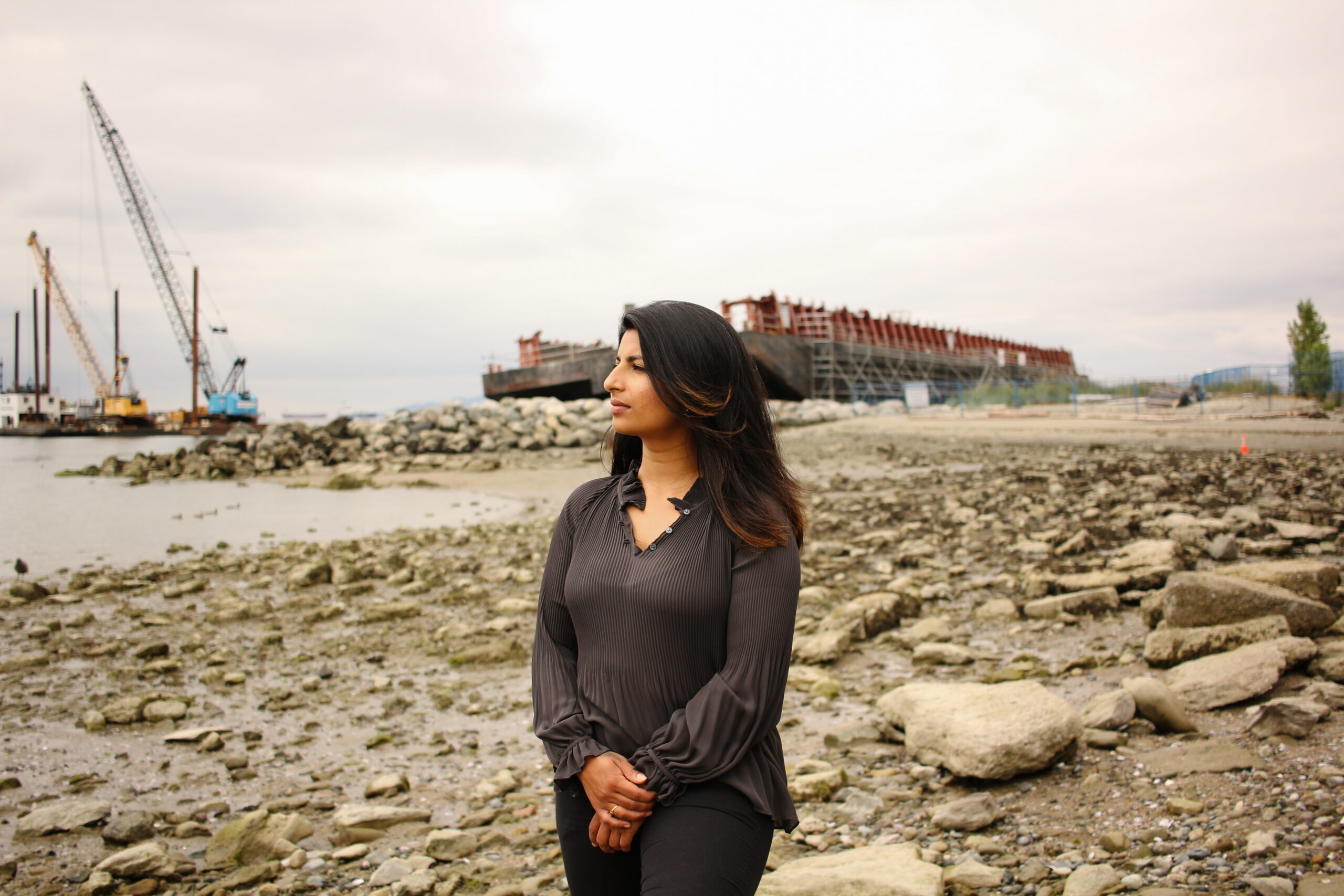 Anjali Appadurai stands in front of a beached barge on Sunset Beach in Vancouver, B.C. Photo by Rebecca Simiyu