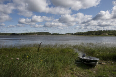 Photo of Grassy Narrow, boat on the shore with lake in the background