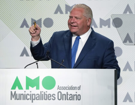 Ontario Premier Doug Ford holds up a toy bee as he jokes about swallowing a bee before speaking to the Association of Municipalities Ontario conference, Monday, August 15, 2022 in Ottawa.