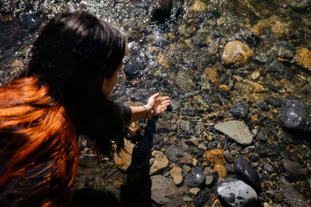 Gitxsan youth Hailey Wilson dips her hand in water