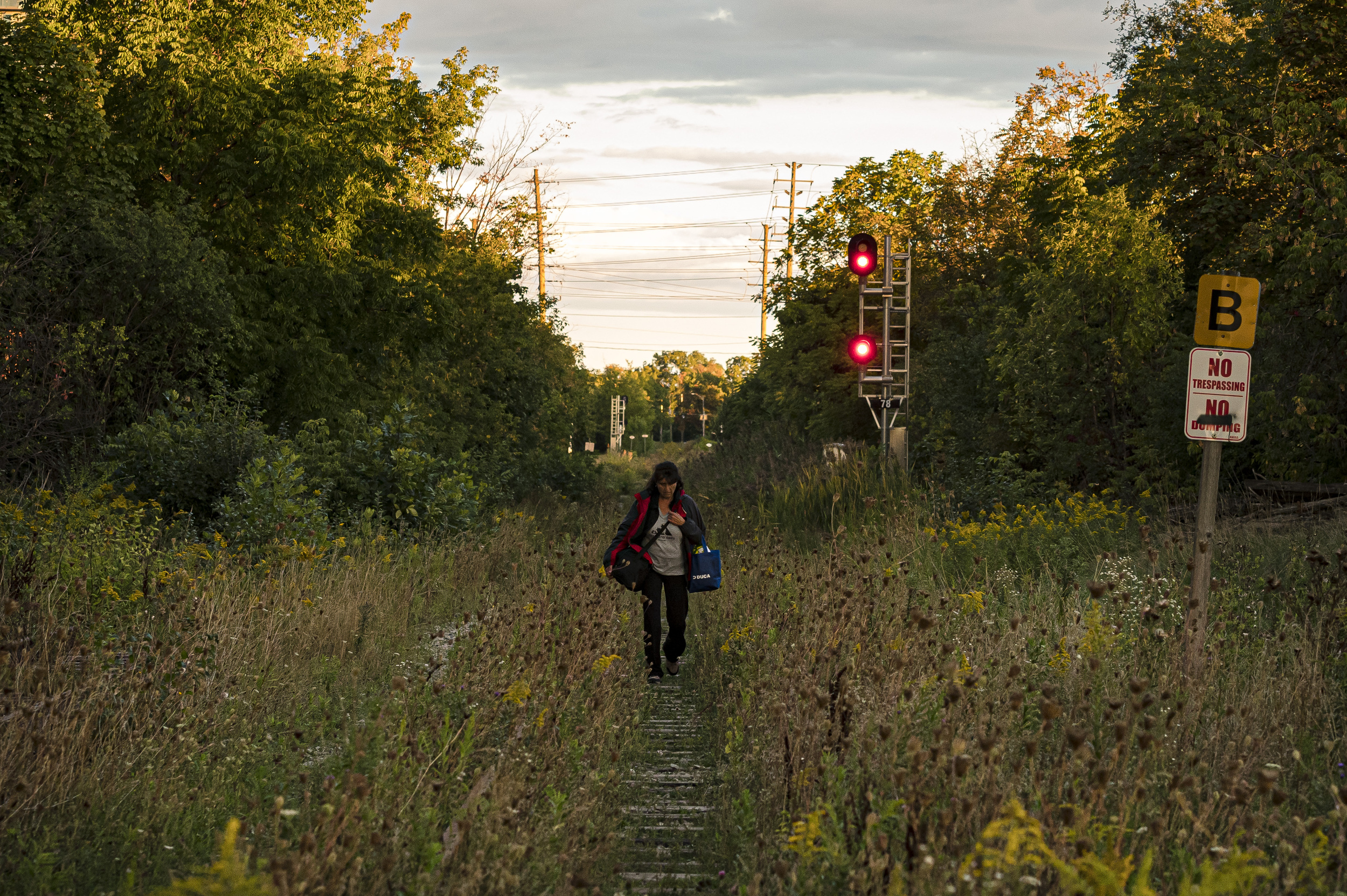 A woman walks along abandoned train tracks in Brampton, Peel Region.