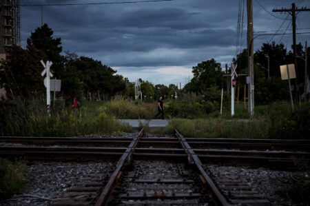 People walk past a section of the 51-kilometre stretch of the Orangeville-Brampton railway, in Brampton, Ont.,