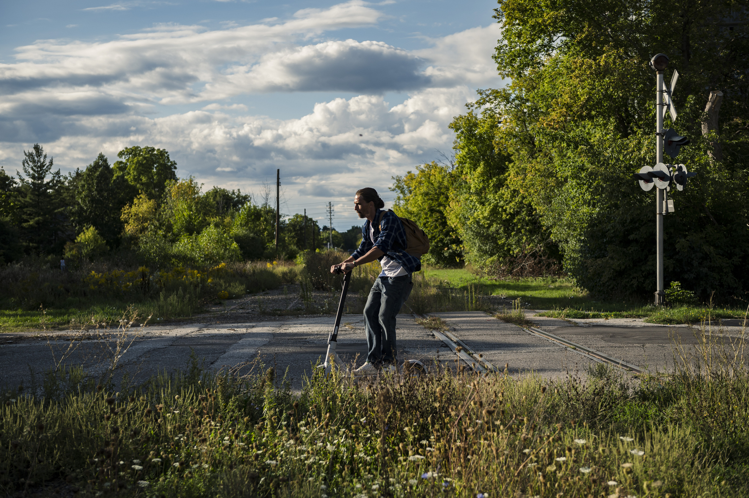 A man travels over the Peel Region rail line in Brampton, Ont. on a scooter.