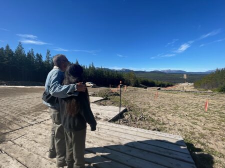 Hereditary Chief Namoks stands arm and arm with Jocey Alec looking at the Coastal GasLink drill site.