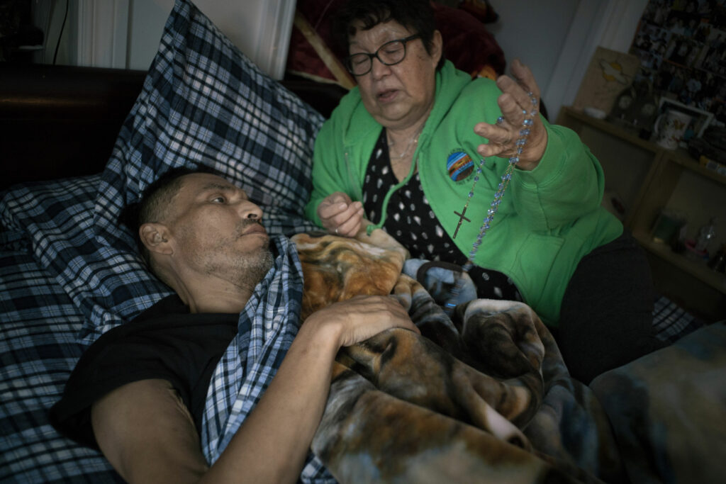 A dying man receiving prayers at his bedside