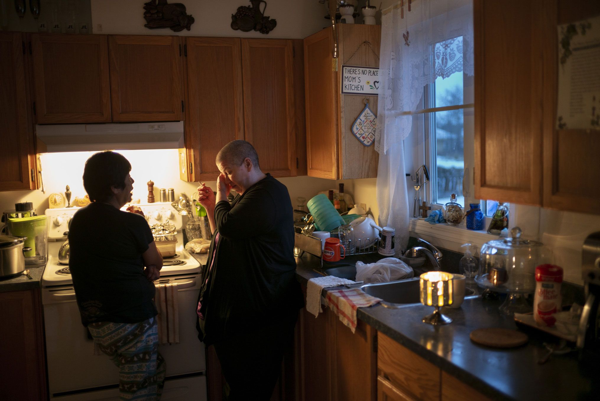 People grieve and smoke in a kitchen