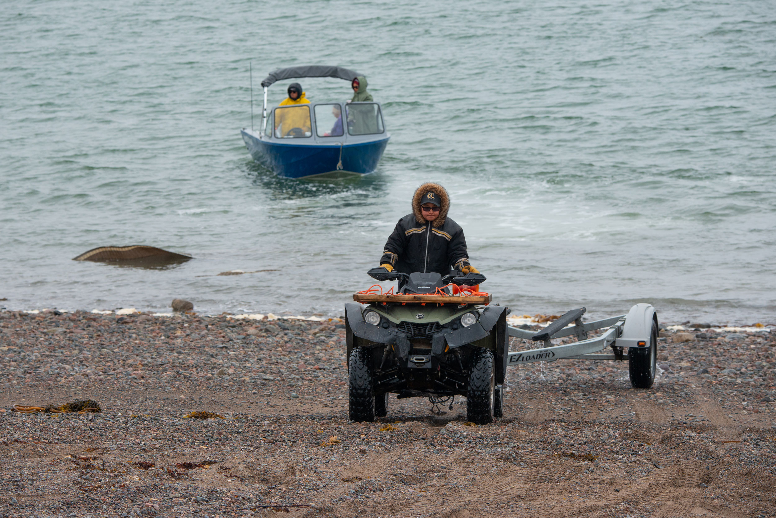 Aupaa Irkok, an instructor with the Young Hunters program, pulls a boat trailer out of the water at the stretch of rocky shoreline the community uses as its launch site. 