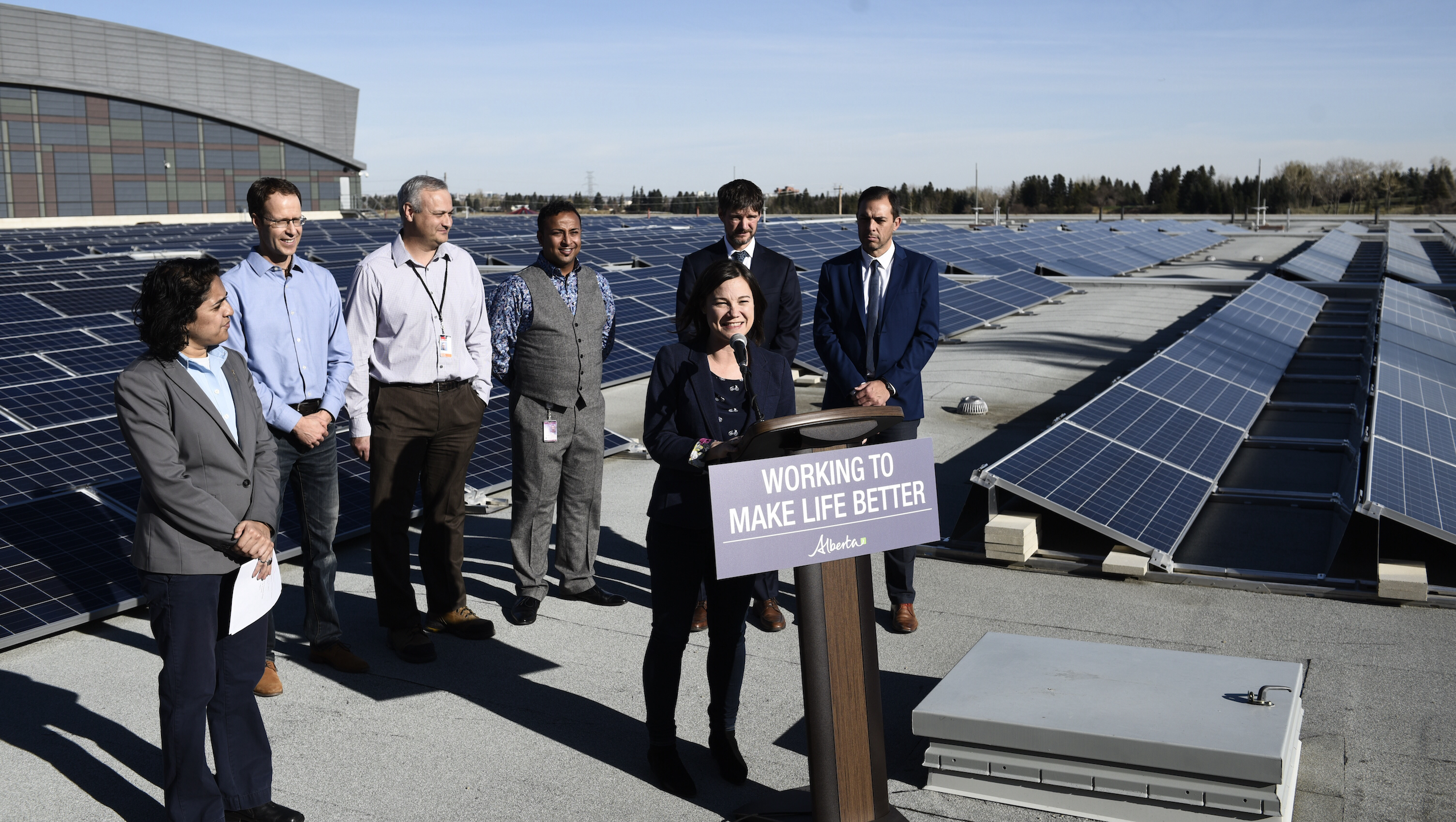 Alberta government officials announce renewable energy programs standing in front of solar array on a sunny day