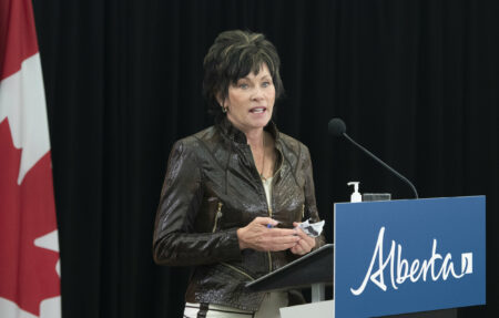 Sonya Savage, former Alberta Energy Minister and current Alberta Environment minister, speaks at a podium.