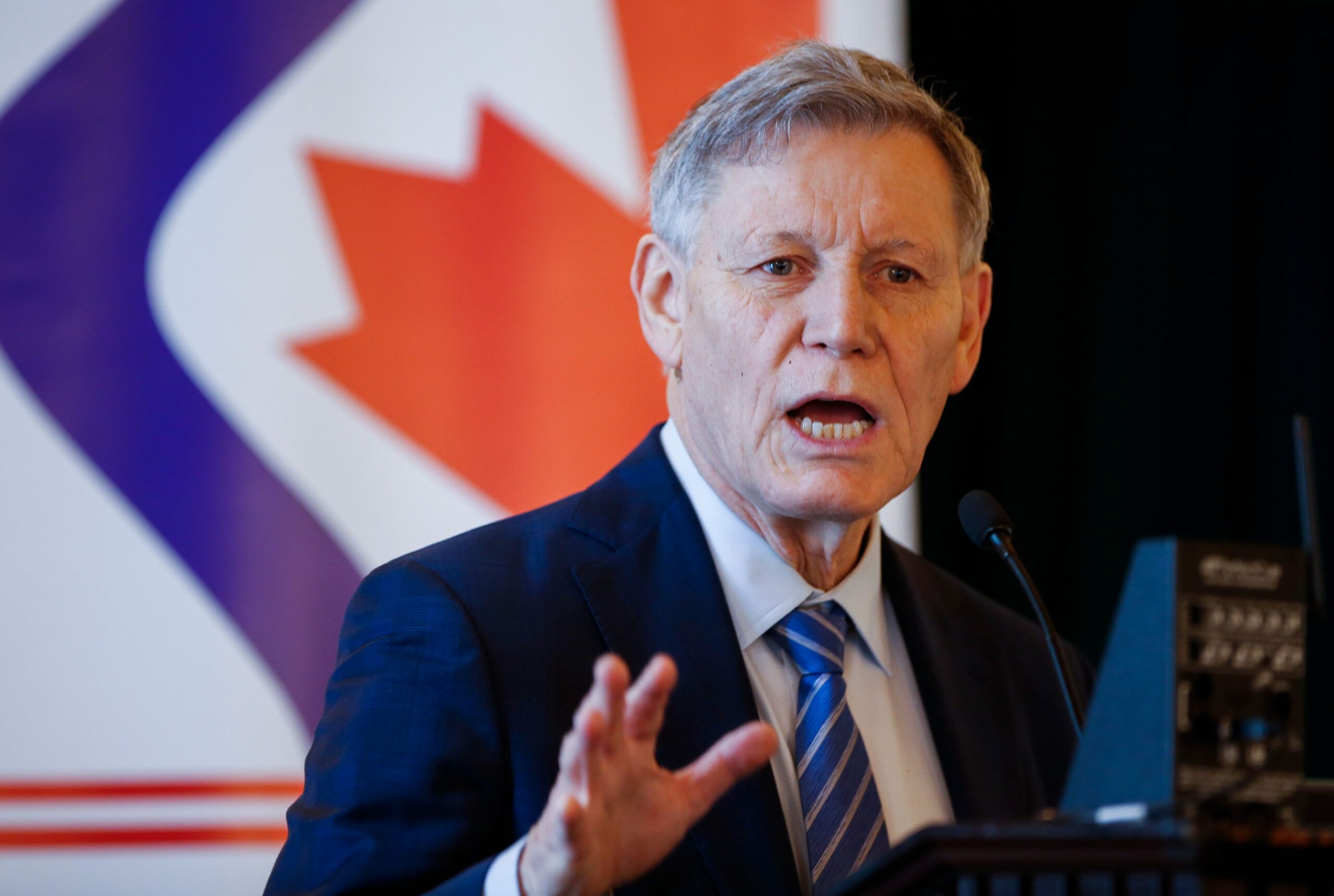 Terry Duguid, Parliamentary Secretary to the Minister of Environment and Climate Change speaks at a Red River Basin Commission event wearing a blue suit and tie