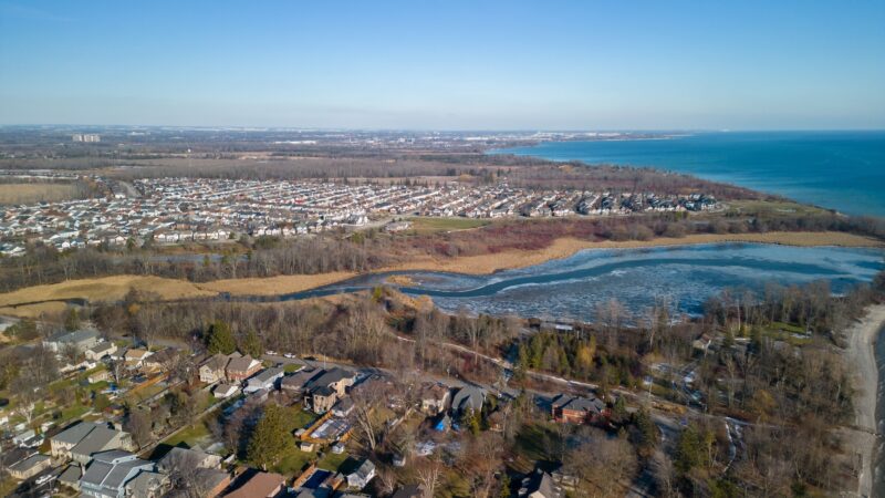 MZO: An aerial view of a Carruthers flowing into Lake Ontario with houses around it