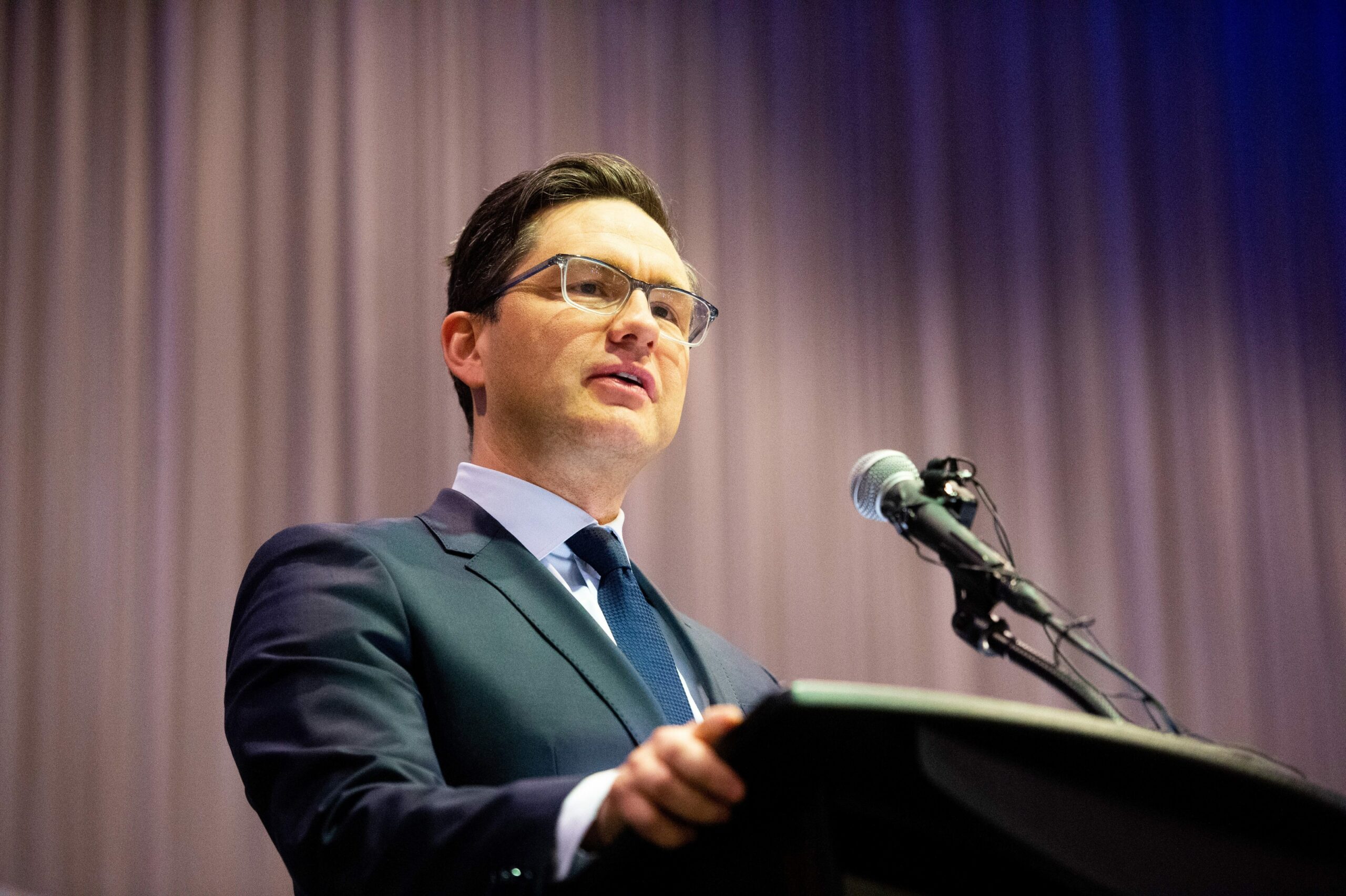 Conservative Party leader Pierre Poilievre stands at a podium to deliver a speech in Manitoba