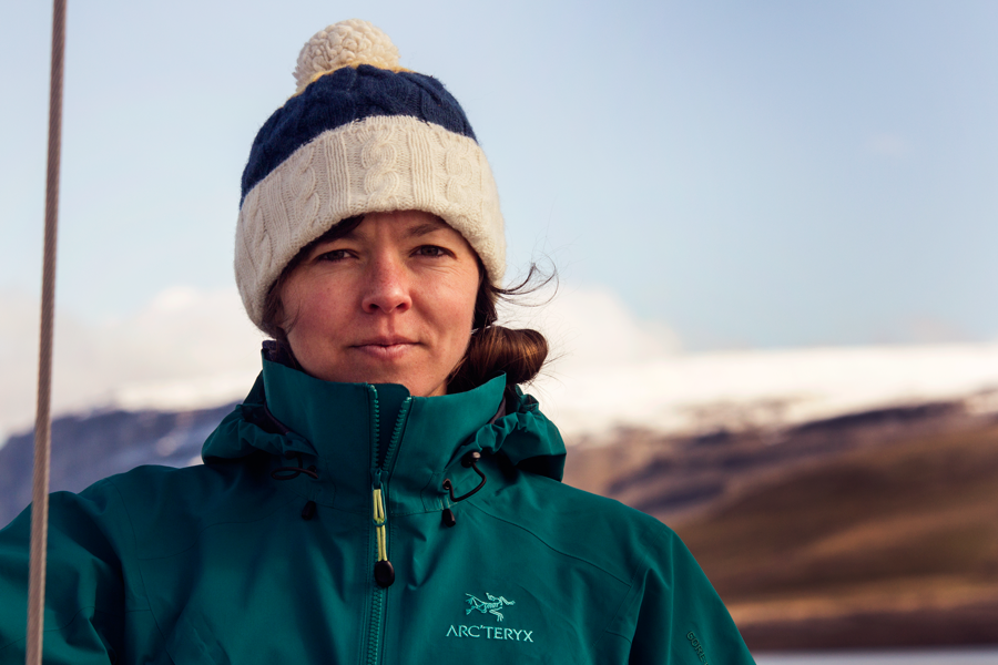 Marine biologist Kristin Westdal wears a green coat and striped toque against a blurred landscape