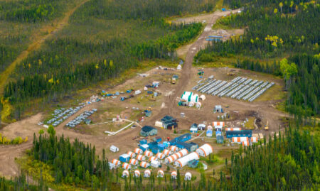 Ontario Ring of Fire: An aerial view of a camp with rows of tents in a clearing in the boreal forest