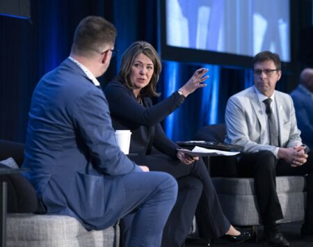 Alberta Premier Danielle Smith speaks on stage at a conference in Edmonton