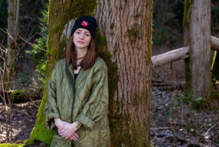 Michelle Cyca leans against a tree