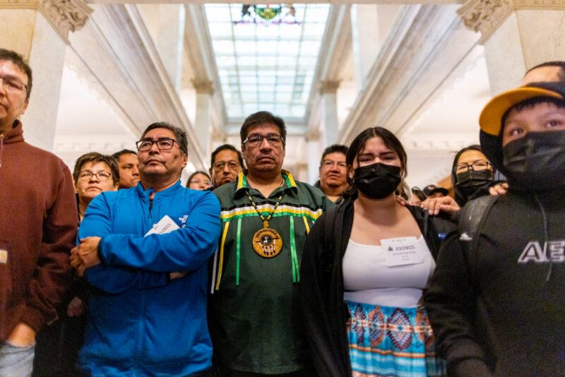 A group of people from First Nations from the Far North stand in the hall of the Ontario Legislature, Queen's Park