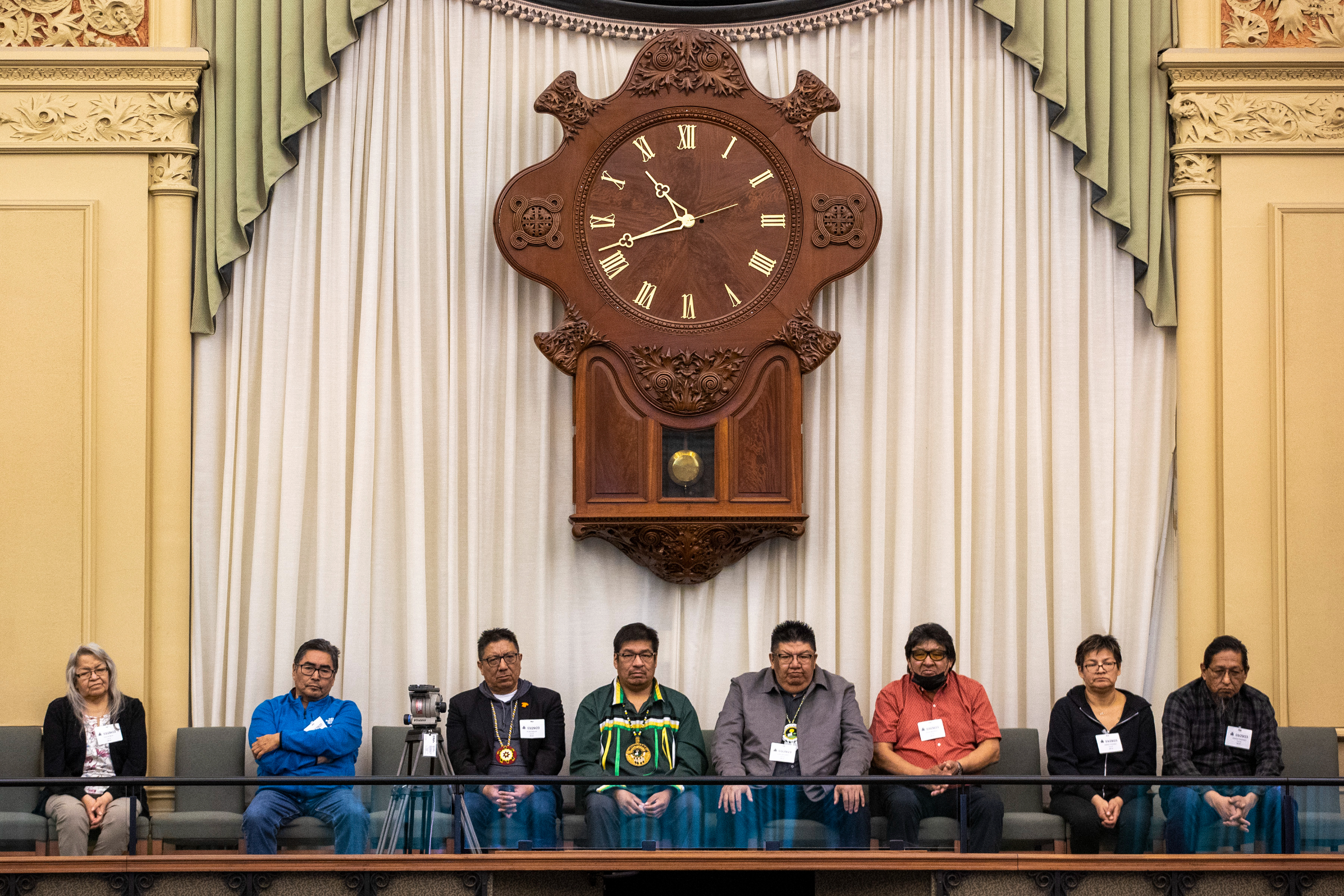 Queen's Park: representatives of four far northern First Nations sit on a balcony at Queen's Park, below a large clock and frilly curtain