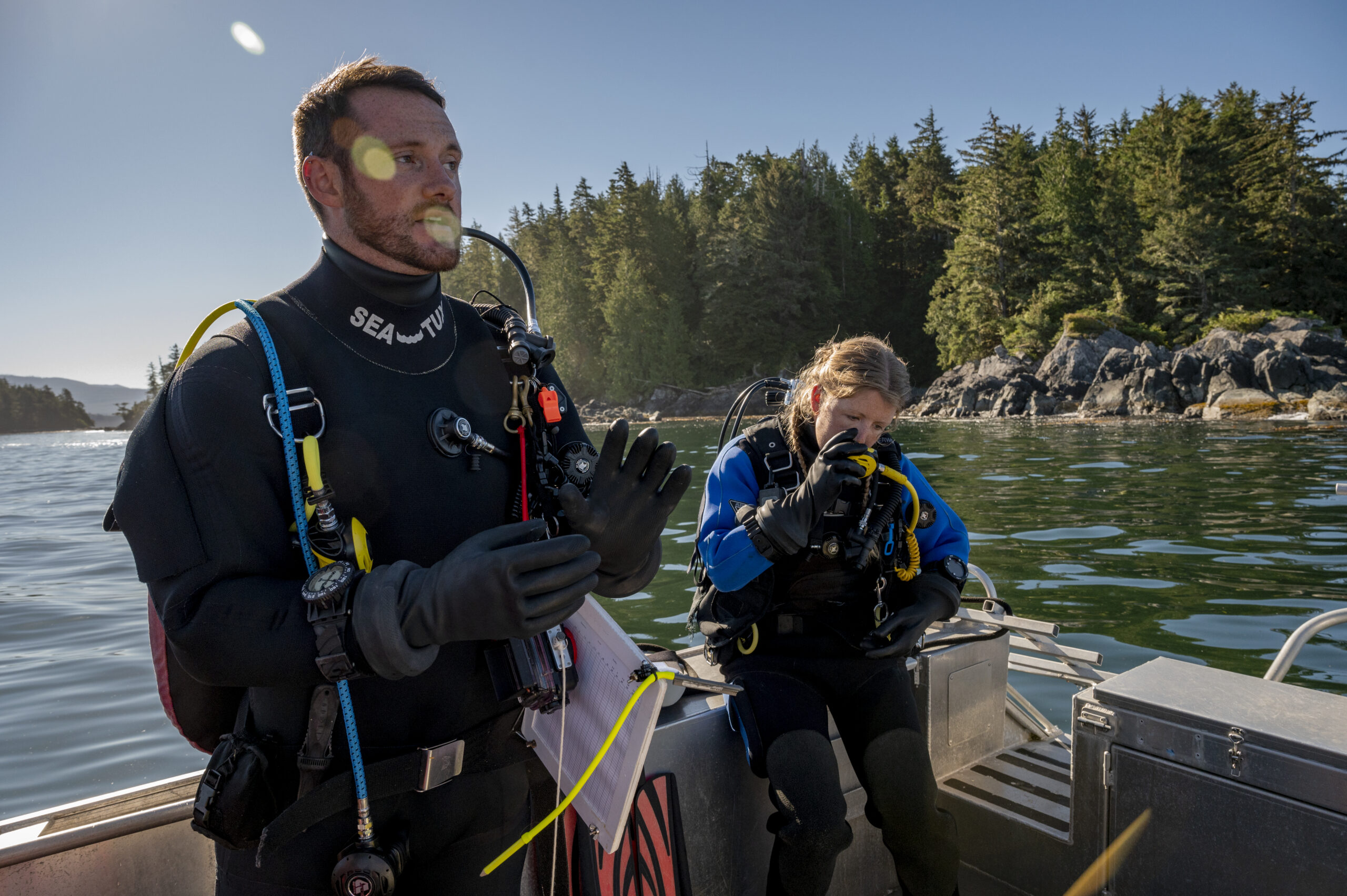 Marine ecologist Kieran Cox and graduate student Claire Attridge gear up for a dive. Attridge tests her regulator.