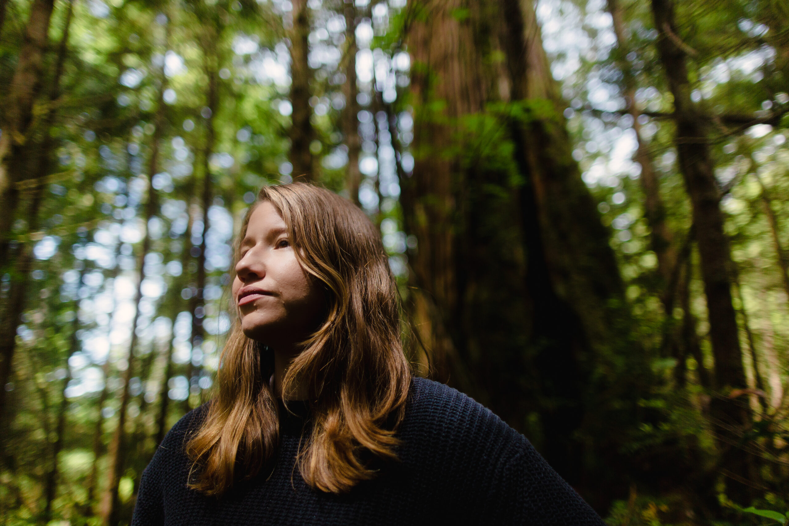 Steph Kwetásel'wet Wood stands in front of old-growth forest on Vancouver Island
