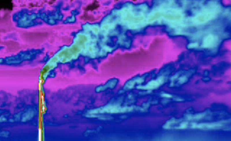 Seen in infrared, methane emissions from an unlit flare billow out of an oil and gas facility