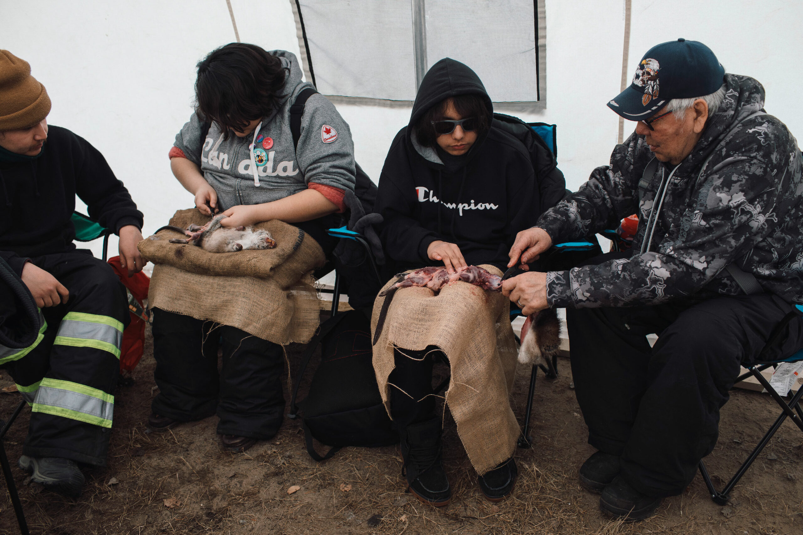 Youth learn to skin muskrats during an elder and youth camp in Fort Chipewyan.