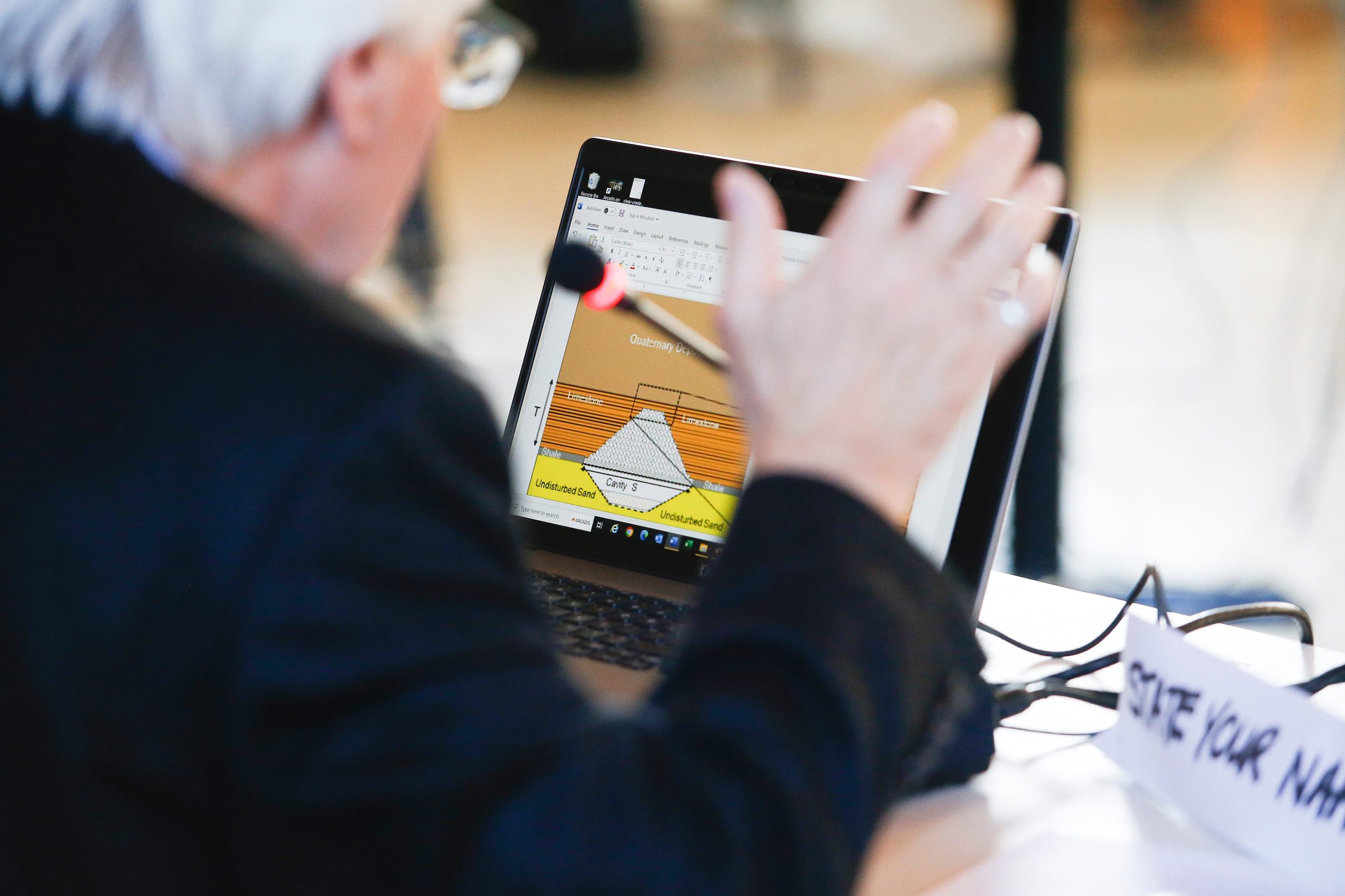 A hydrogeologist looks at his laptop while presenting evidence regarding Sio Silica's proposed sand mining technique during clean environment commission hearings in Steinbach, Manitoba