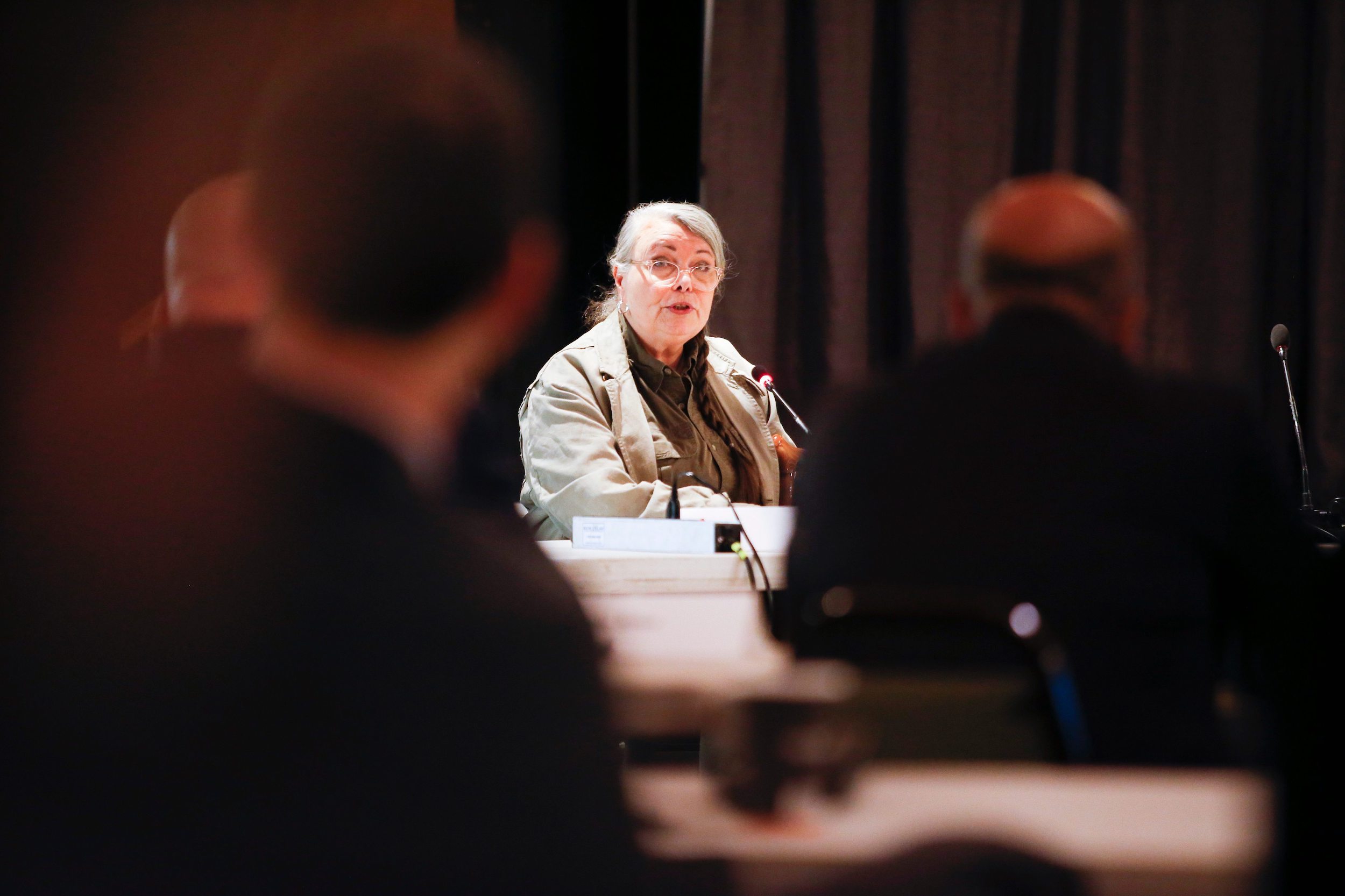A resident wearing green clothing and glasses speaks during clean environment commission hearings in Steinbach, Manitoba