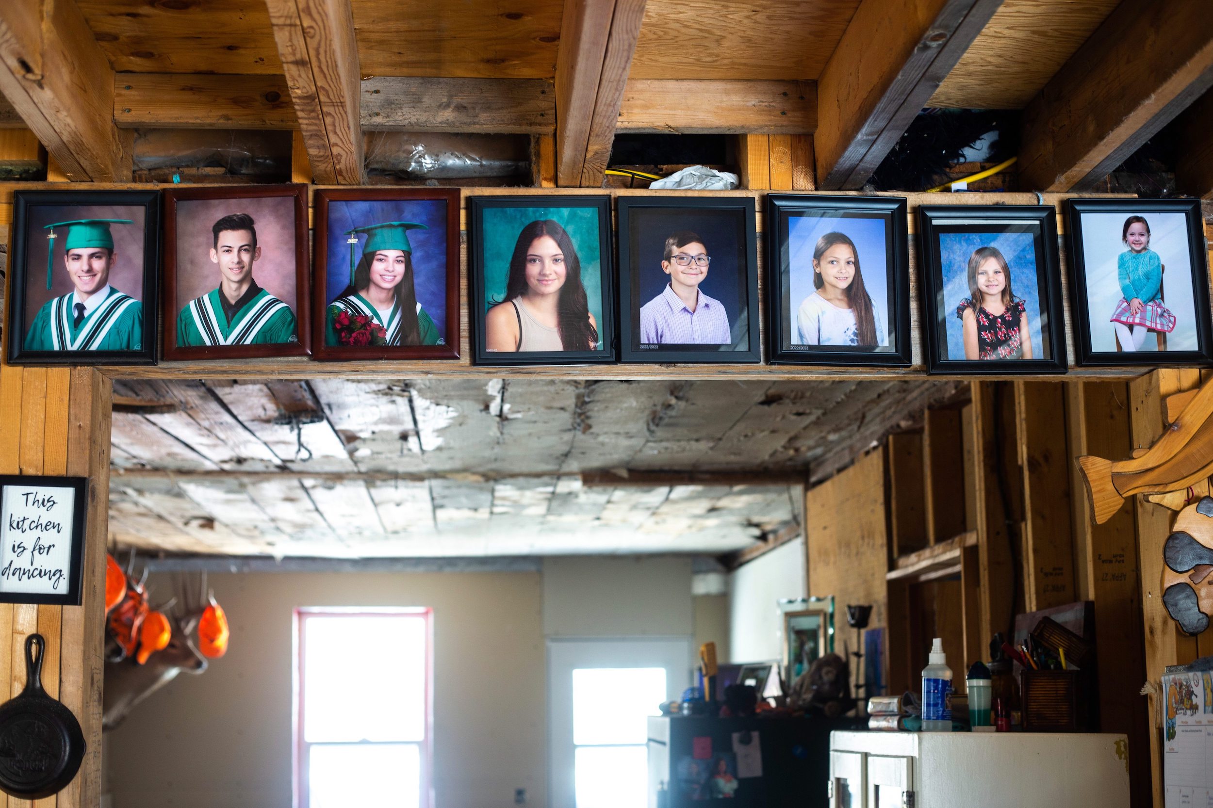 Framed photos of the eight Mustard children hang, from oldest to youngest, on the doorway between the living room and kitchen in their home near Vivian, Manitoba
