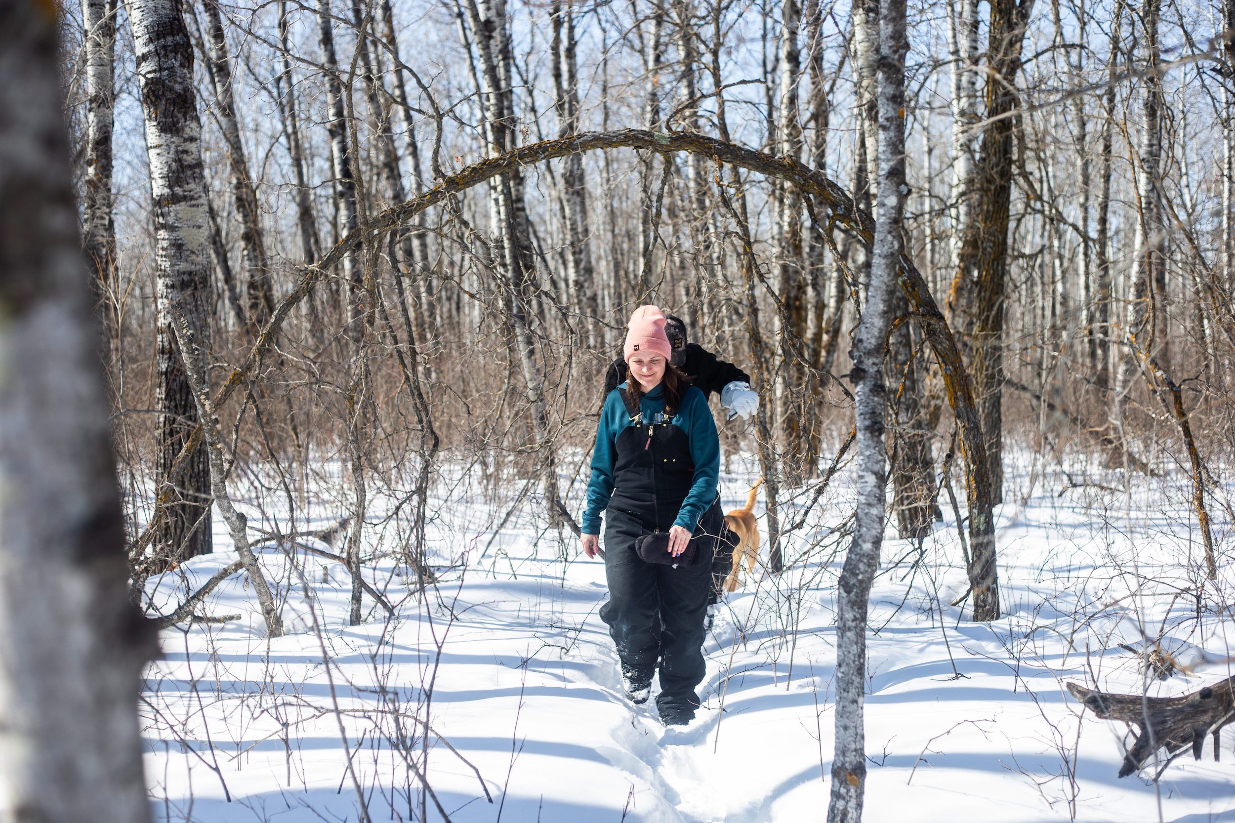 Georgina Mustard leads her husband, Josh, through the woods on the edge of their property near Vivian, Manitoba