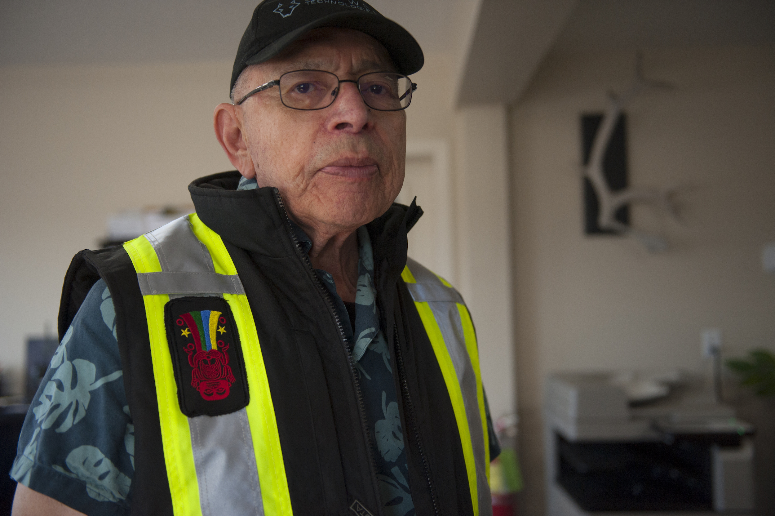 Gitxsan Chief Hanamuxw poses in a high-visibility vest bearing his clan crest