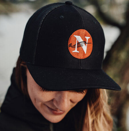 The Narwhal's executive director, Emma Gilchrist, looks down while wearing a black cap with a Narwhal logo