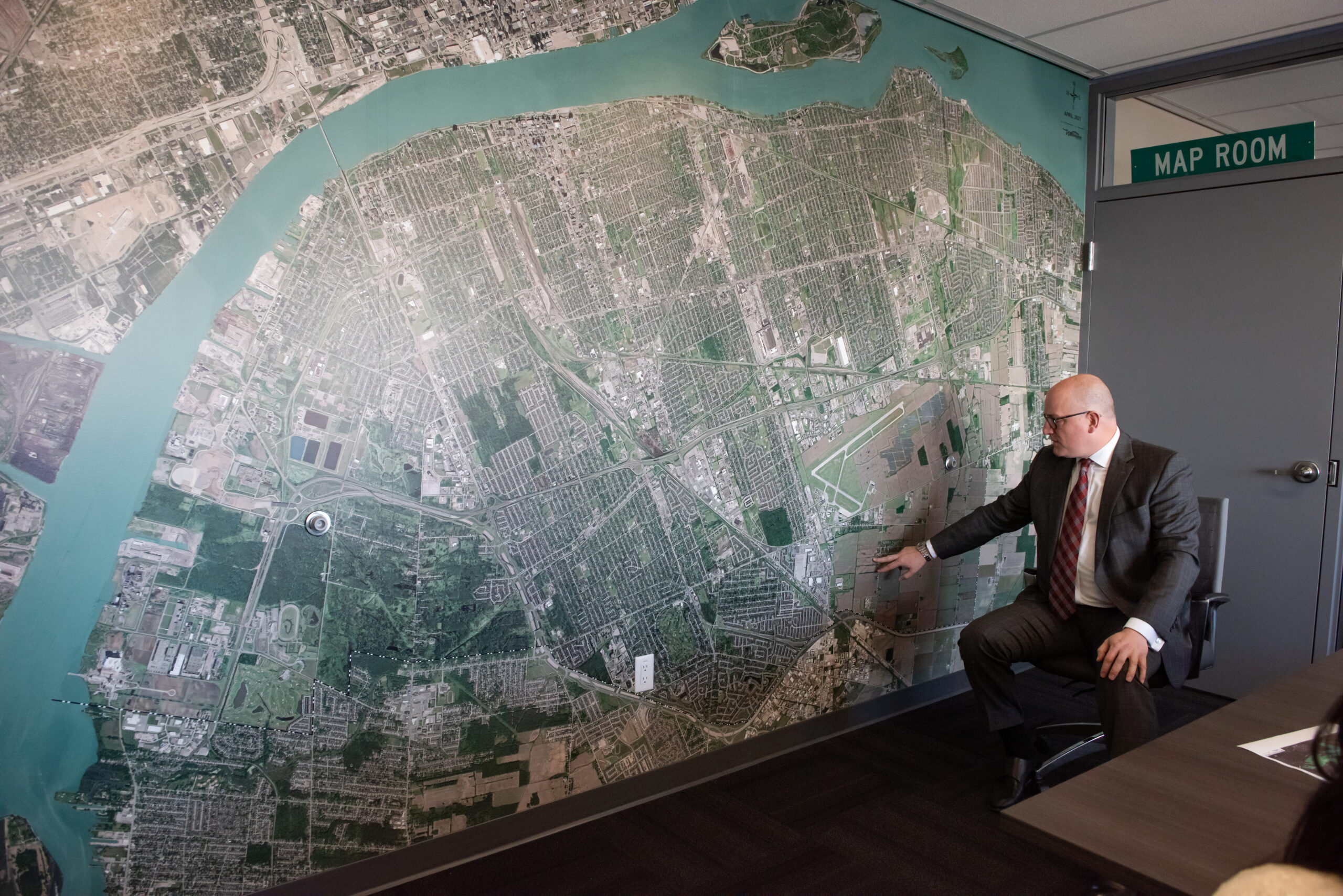 Windsor Mayor Drew Dilkens points at open farmland on a map in his office to indicate the site of future development