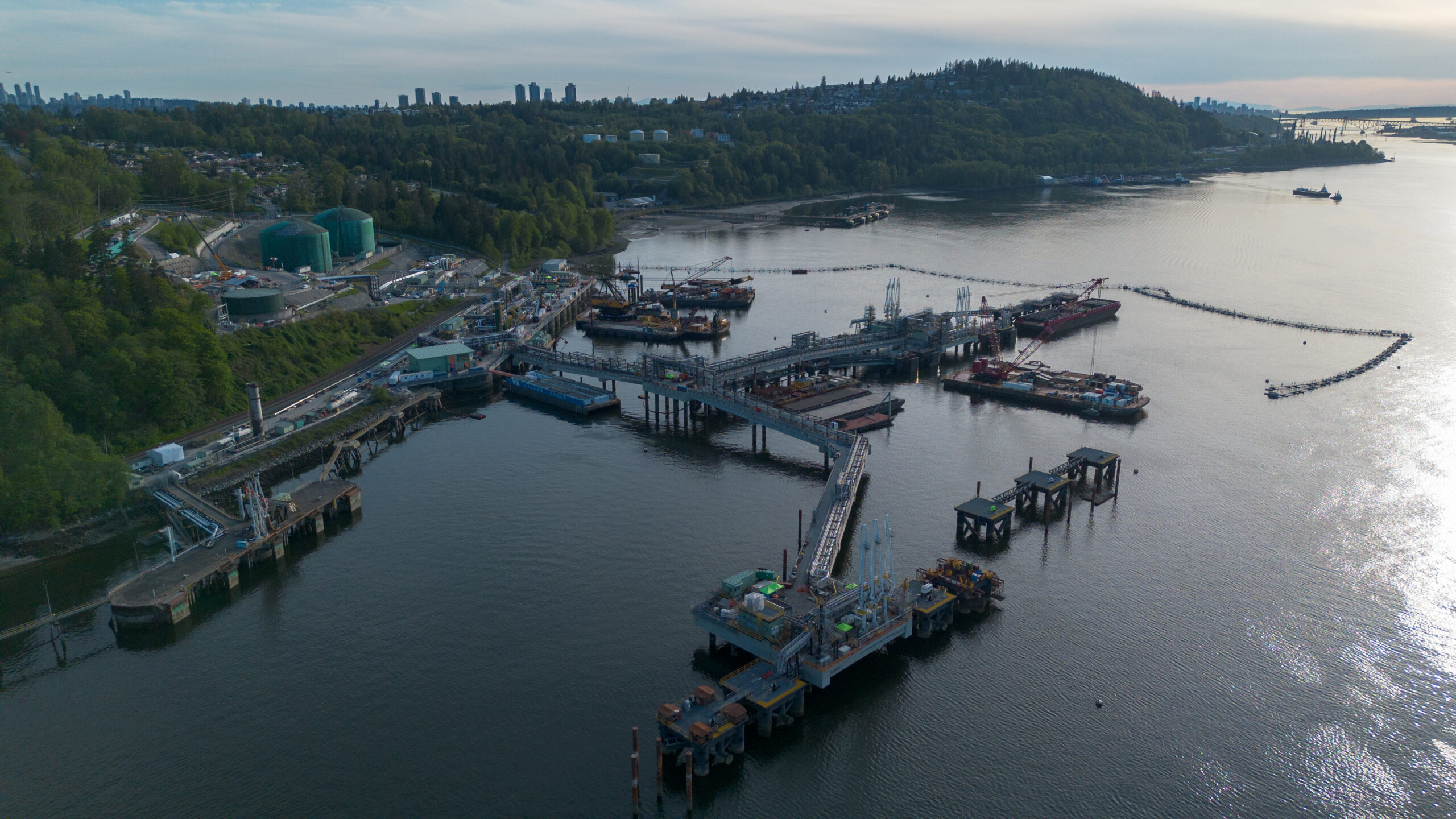 Aerial view of an oil marine terminal set against a mountainous background. 