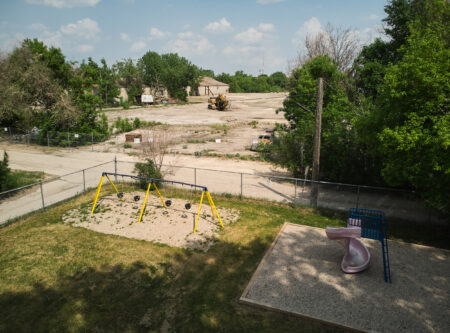 A playground in Winnipeg's Point Douglas neighbourhood sits adjacent to a vacant industrial lot