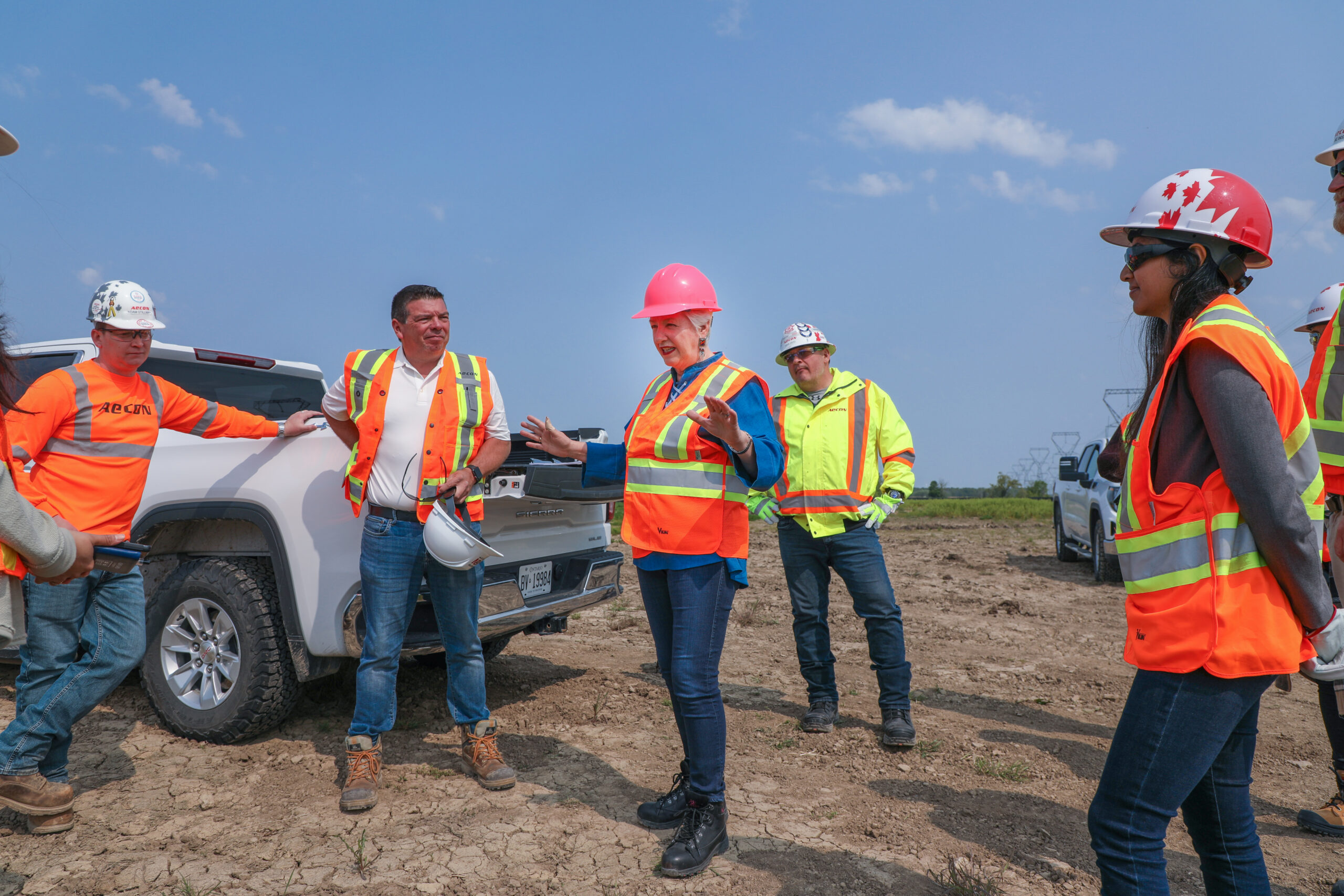Six Nations: group of five people pictured standing at a worksite with hardhats and orange vests.