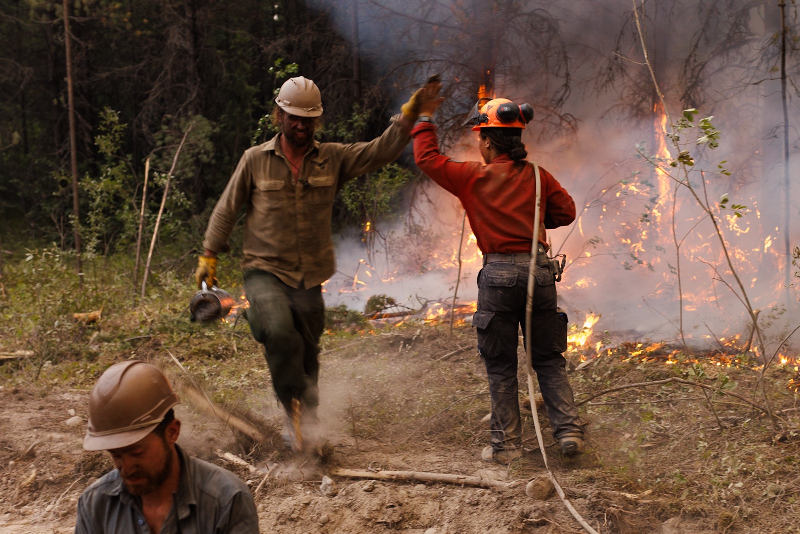 BC Wildfire: Two firefighters high-five while working on a planned ignition on a wildfire in northern B.C.
