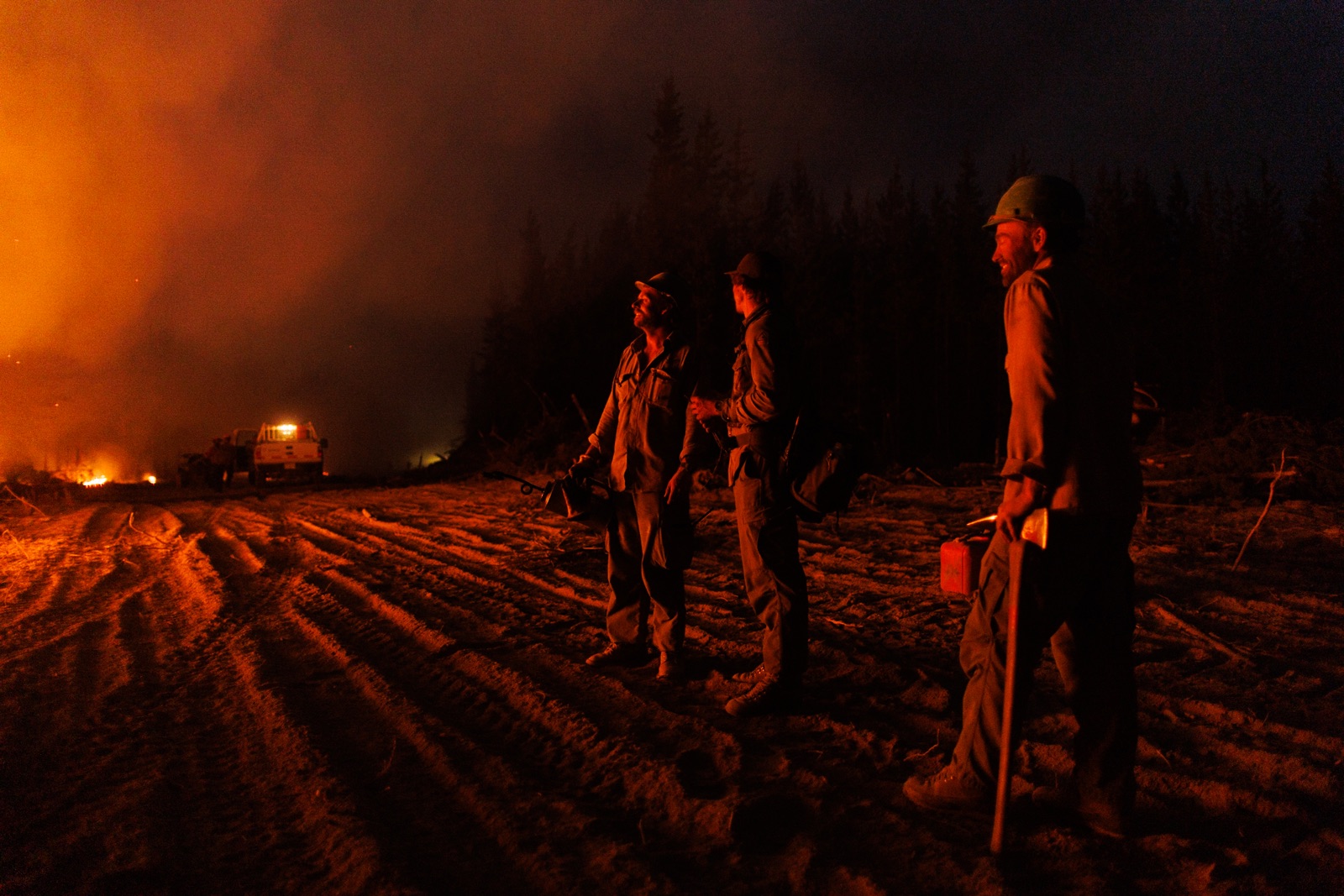 BC Wildfire: Wildfire fighters watch as a planned ignition takes off at night on a wildfire in northern BC