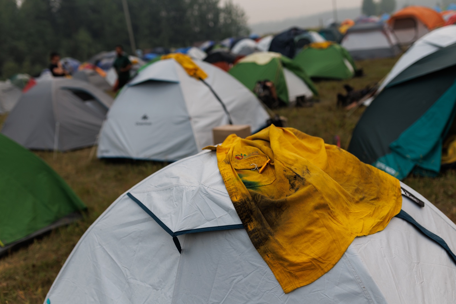 a yellow shirt sits on top of a tent in a field of tents