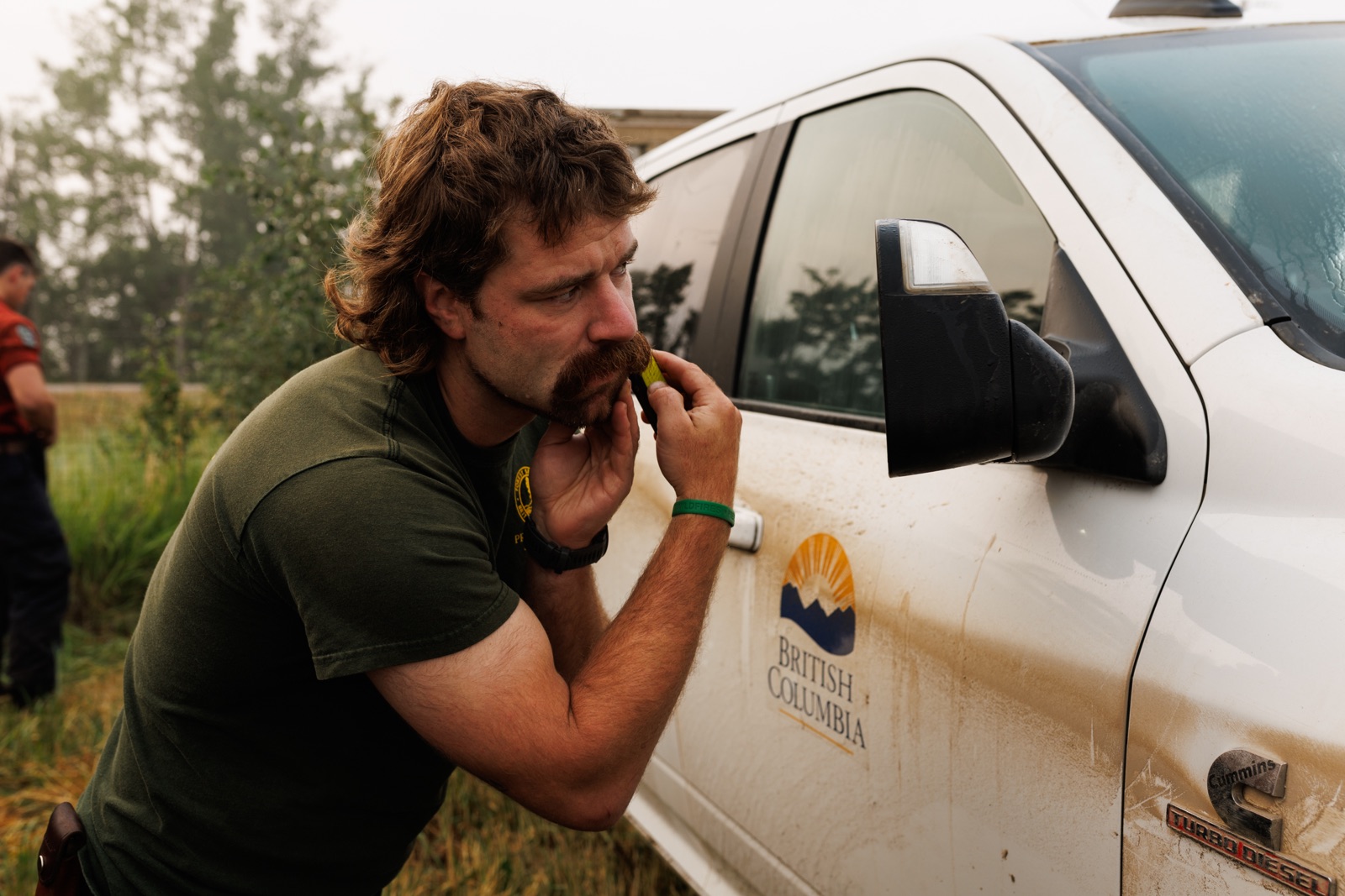 Firefighter Al Ritchie shaves with the help of his truck side mirror