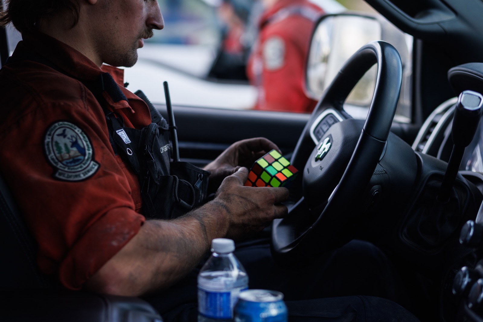 A firefighter passes the time with a Rubik's Cube in his truck