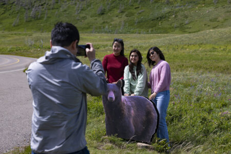 Tourists pose for a photo in front of a cutout of a black bear in Waterton Lakes National Park