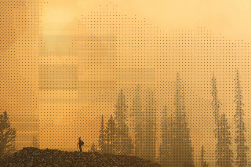 A B.C. wildfire fighter stands on a ridge in a smoky forest that has an orange haze with pixelated illustration overlaid.