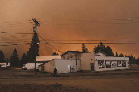 A masked resident stopped to take a last look at their town before evacuating to the boat launch on bike.