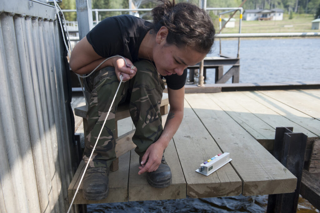 A fisheries worker with Lake Babine Nation counts salmon as they pass